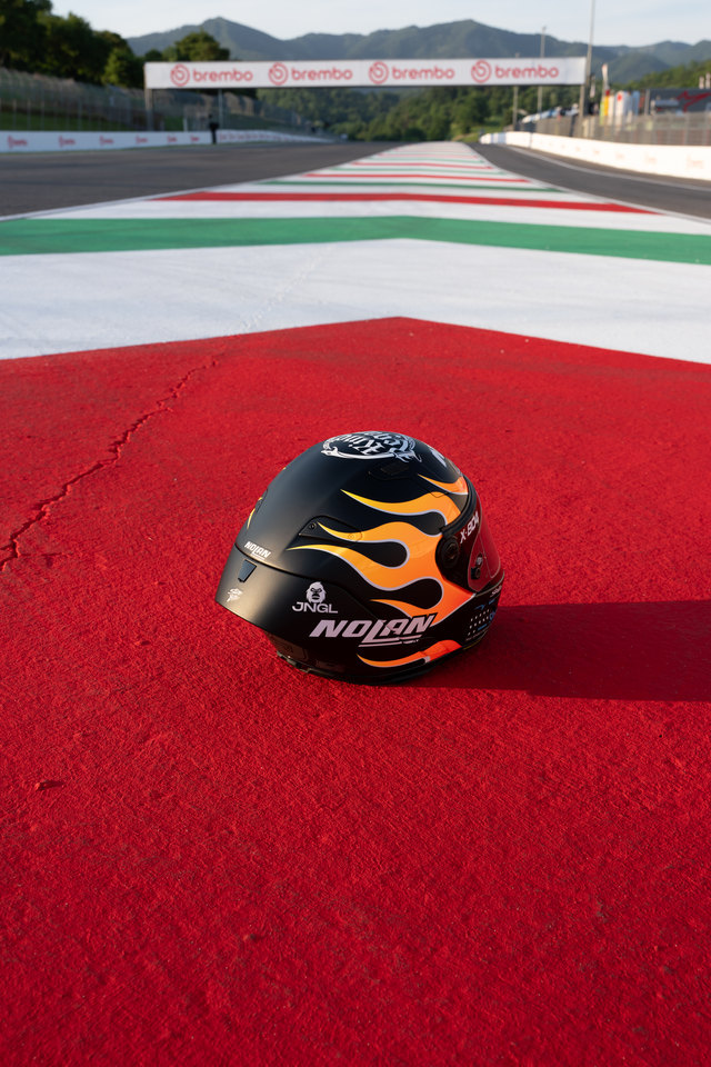Mugello — casco sul cordolo, vista a tre quarti.